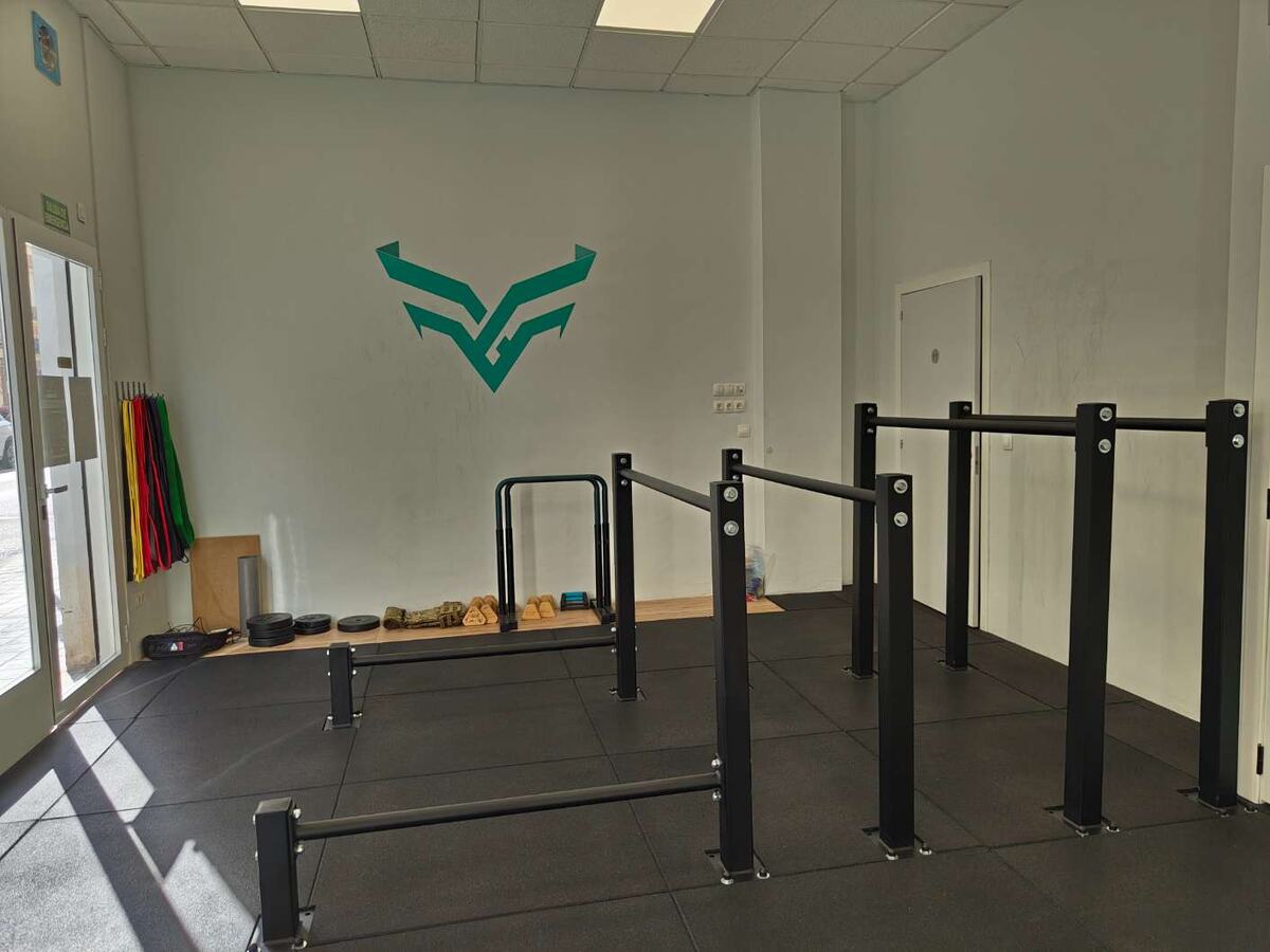 Zona de paralelas con el logo de Calistenia Valencia en la pared